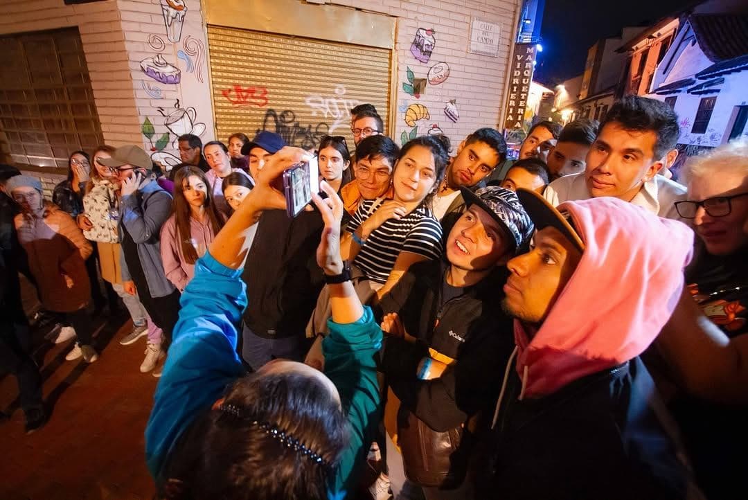 Participantes sorprendidos rodeando a la guía en una esquina con grafitis